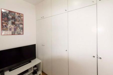 Apartamento à venda com 85m², 2 quartos e sem vagaTelevisão e prateleira de TV em uma sala branca com quadro de fotos na parede.
