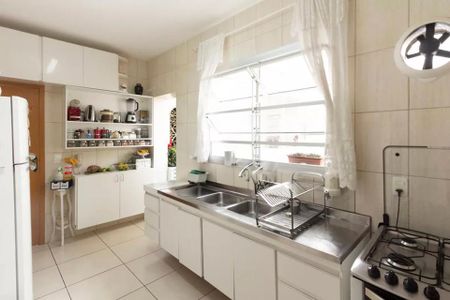 Apartamento à venda com 85m², 2 quartos e sem vagaCozinha com móveis brancos, piso de porcelanato, janela grande e iluminação natural.