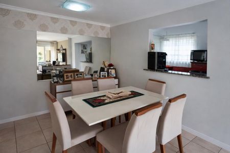 Apartamento à venda com 72m², 3 quartos e 2 vagasComedor com mesa branca e cadeiras de cor creme, com uma parede de espelho e uma janela com cortinas claras.