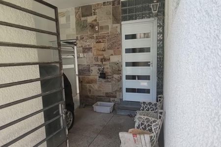 Casa à venda com 260m², 4 quartos e 3 vagasPorch with stone wall, white door, and metal gate, possibly in a Brazilian house.