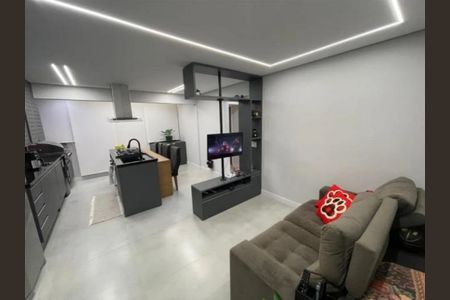 Sala de estar com sofá, TV e cozinha integrada, iluminada por luzes de parede e teto. de apartamento à venda com 2 quartos, 55m² em São Pedro, Osasco