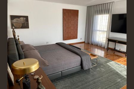 Apartamento à venda com 466m², 4 quartos e 6 vagasCama com colchão e travesseiro, mesa de cabeceira e TV na parede, com uma pintura de arte na parede.