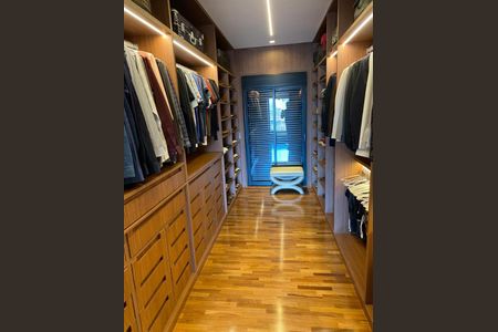 Apartamento à venda com 466m², 4 quartos e 6 vagasCloset com iluminação de LED e madeira, com uma porta de vidro e uma banqueta branca.