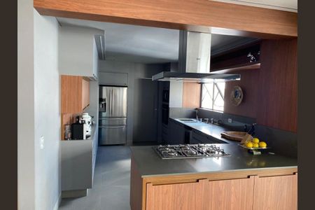 Apartamento à venda com 466m², 4 quartos e 6 vagasCozinha moderna com iluminação natural e acabamento em madeira e pedra.