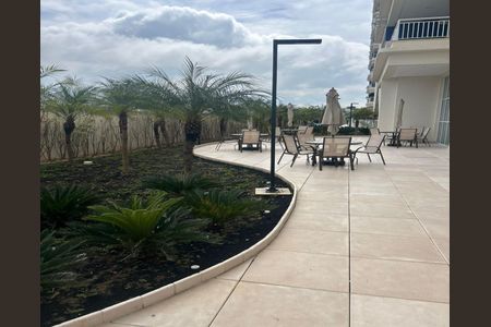 Apartamento à venda com 55m², 2 quartos e 1 vagaVaranda com vista para o mar, com móveis de jardim e palmeiras.