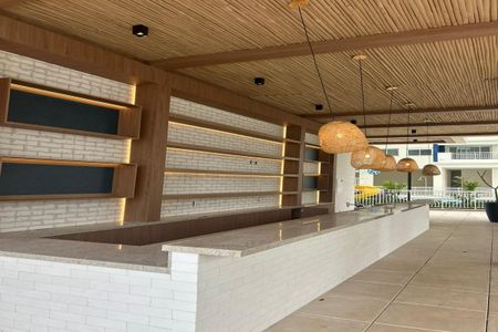 Apartamento à venda com 55m², 2 quartos e 1 vagaBarra de madeira com iluminação e prateleiras de gesso.