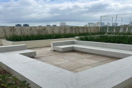 Apartamento à venda com 55m², 2 quartos e 1 vagaPatio com vista para a cidade, com bancos de granito e plantas ao redor.