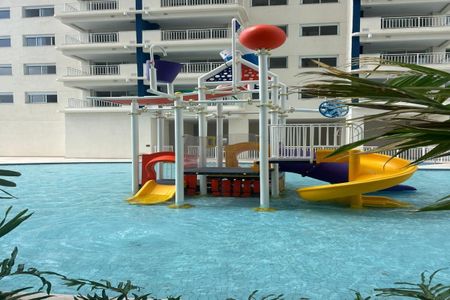 Apartamento à venda com 55m², 2 quartos e 1 vagaPiscina com equipamento de brinquedos para crianças, com vista para o prédio de apartamentos.