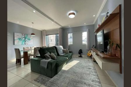 Sala com sofá verde, mesa de jantar e TV em uma casa moderna. de casa à venda com 4 quartos, 200m² em Jardim Porteira Grande, São Paulo