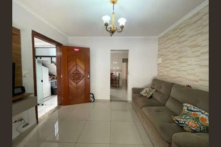 Sala com sofá e chândeleira, com vista para a cozinha e a escada. de casa à venda com 4 quartos, 200m² em Jardim Porteira Grande, São Paulo