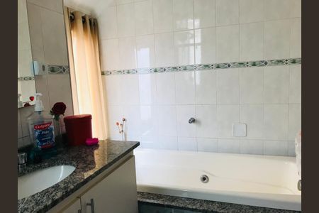 Casa à venda com 170m², 3 quartos e 5 vagasBanheiro com pia e banheira branca, com azulejos brancos e azuis, e um espelho grande na parede.