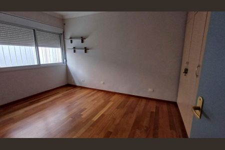 Casa à venda com 340m², 4 quartos e 4 vagasQuarto com piso de madeira, janelas grandes e iluminação natural, sem móveis ou decoração.