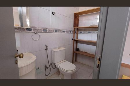 Casa à venda com 340m², 4 quartos e 4 vagasBanheiro com piso de porcelanato, vaso sanitário e lavabo, com prateleiras de madeira.