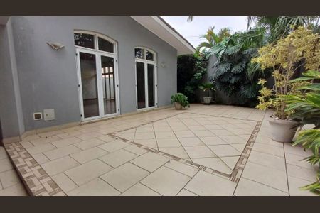 Casa à venda com 340m², 4 quartos e 4 vagasPátio com piso de azulejos e plantas ao redor.
