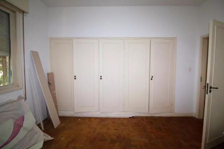 Casa à venda com 400m², 4 quartos e 6 vagasCabinete de armários brancos em uma sala com piso de madeira e janela.