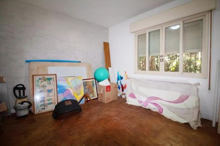 Casa à venda com 400m², 4 quartos e 6 vagasEspaço de trabalho com pinturas e equipamentos de ginástica, com janela e piso de madeira.