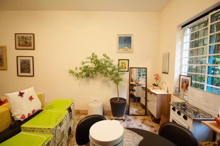 Casa à venda com 400m², 4 quartos e 6 vagasSala com móveis coloridos, plantas e quadros na parede, com uma janela grande e iluminada.