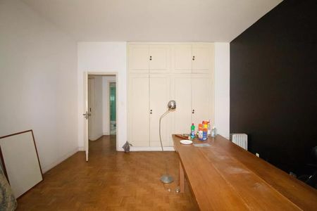 Casa à venda com 400m², 4 quartos e 6 vagasSala com móveis brancos e madeira, iluminada por uma lâmpada de piso, com um radiador na parede.