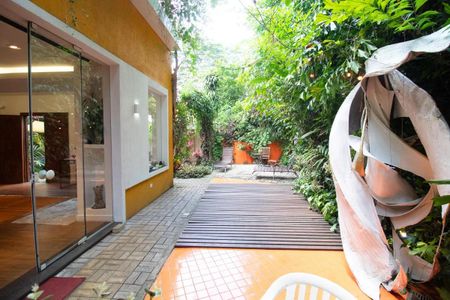 Casa à venda com 400m², 4 quartos e 6 vagasPátio com decoração de jardim e mobiliário de madeira e metal.