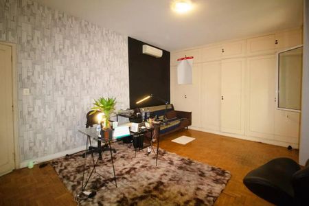 Casa à venda com 400m², 4 quartos e 6 vagasEscritório com mesa de vidro, cadeira, plantas, e papelaria.