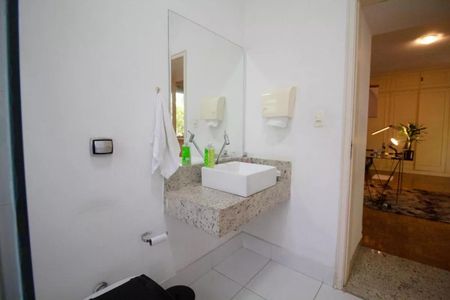 Casa à venda com 400m², 4 quartos e 6 vagasBanheiro com pia e espelho, com uma toalha branca pendurada no espelho.
