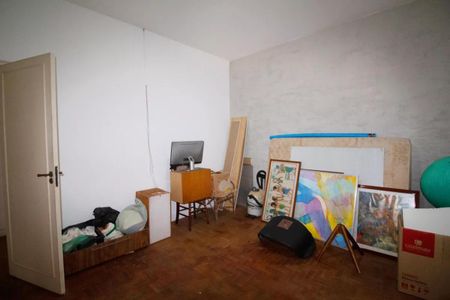 Casa à venda com 400m², 4 quartos e 6 vagasEspaça de trabalho com computador e quadros na parede, com mobiliário simples e piso de madeira.
