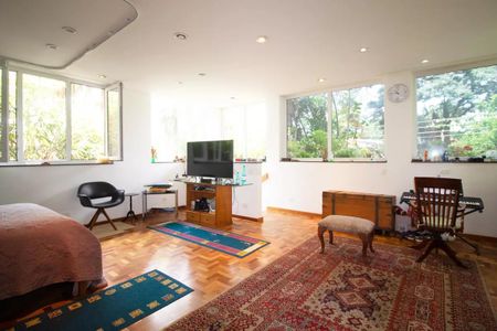Casa à venda com 400m², 4 quartos e 6 vagasQuarto com cama, TV, móveis e janelas com vista para o jardim.