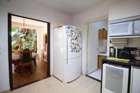 Casa à venda com 400m², 4 quartos e 6 vagasCasa com cozinha moderna e jardim ao fundo, com mesa de jantar e cadeiras de madeira.