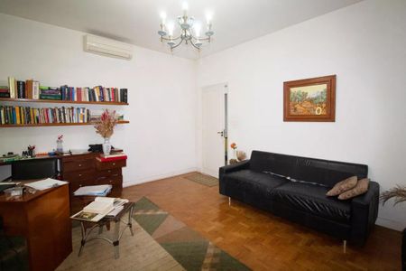 Casa à venda com 400m², 4 quartos e 6 vagasSala com móveis de madeira e um sofá preto, com uma mesa de trabalho e uma estante de livros.