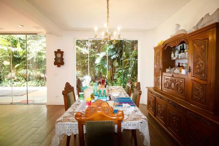 Casa à venda com 400m², 4 quartos e 6 vagasSala com mesa de jantar e armário de madeira, com vista para o jardim.