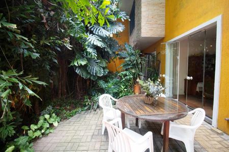 Casa à venda com 400m², 4 quartos e 6 vagasPátio com mesa e cadeiras, cercado por plantas e árvores.