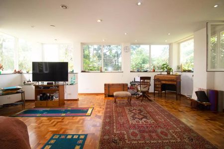 Casa à venda com 400m², 4 quartos e 6 vagasSala com TV, sofá, mesa, cadeira e janela com vista para o jardim.