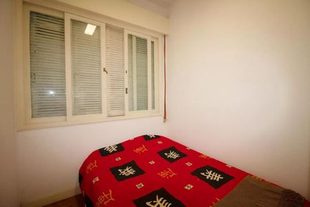 Casa à venda com 400m², 4 quartos e 6 vagasCama com cobertor vermelho e padrão de cores e símbolos brancos e pretos, com janela com persianas fechadas.