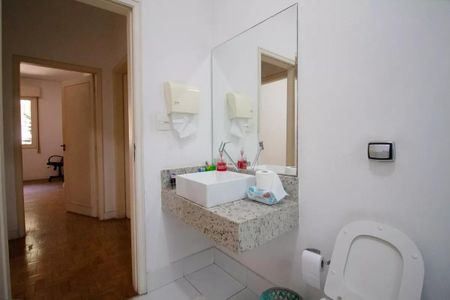 Casa à venda com 400m², 4 quartos e 6 vagasBanheiro com pia e vaso sanitário, com uma porta de vidro e uma janela ao fundo.