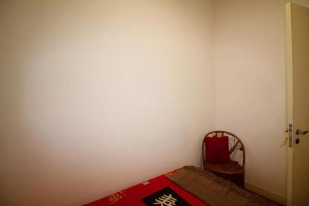 Casa à venda com 400m², 4 quartos e 6 vagasQuarto com cama simples, cadeira e porta, com iluminação fraca e decoração simples.