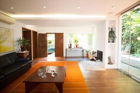 Casa à venda com 400m², 4 quartos e 6 vagasSala com móveis modernos e decoração minimalista, com vista para a varanda e jardim.