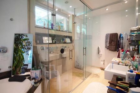 Casa à venda com 400m², 4 quartos e 6 vagasBanheiro com chuveiro e banheira, com uma janela e uma planta ao lado do espelho.