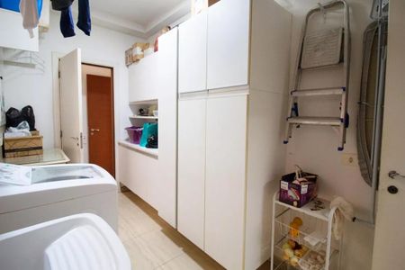 Casa à venda com 400m², 4 quartos e 6 vagasVaranda com lavanderia e armários brancos, com uma porta de madeira na parede.
