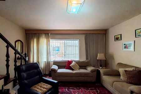 Sala com sofás, cadeira, tapete vermelho e janela com cortinas claras. de casa à venda com 3 quartos, 142m² em Alto da Lapa, São Paulo
