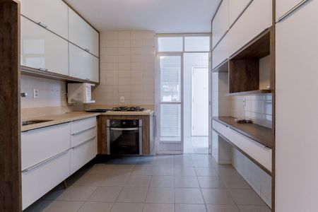 Apartamento à venda com 110m², 2 quartos e 1 vagaCozinha com móveis brancos e madeira, fogão e geladeira, iluminação boa, piso de porcelanato, bancada de granito, janelas grandes, nenhuma decoração.