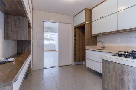 Apartamento à venda com 110m², 2 quartos e 1 vagaCozinha com móveis de madeira e azulejos brancos, com uma janela grande e iluminação boa.