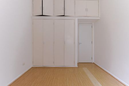 Apartamento à venda com 110m², 2 quartos e 1 vagaCuarto com armários e gavetas, piso de madeira e porta de vidro.