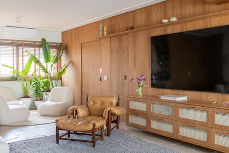Apartamento à venda com 160m², 2 quartos e 3 vagasSala de estar com móveis de couro e madeira, iluminação natural e plantas.