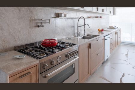 Apartamento à venda com 160m², 2 quartos e 3 vagasCozinha com fogão, forno e pia, com móveis de madeira e azulejos brancos.