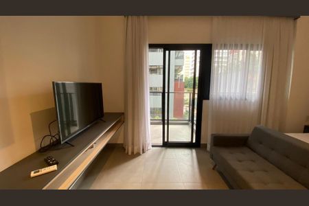 Sala com TV e sofá, com vista para varanda e edifícios ao fundo. de kitnet/studio à venda com 1 quarto, 29m² em Pinheiros, São Paulo