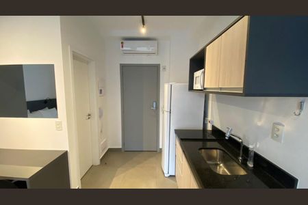 Quarto com cama, mesa e ar condicionado, com uma porta para o banheiro e uma porta para a cozinha. de kitnet/studio à venda com 1 quarto, 29m² em Pinheiros, São Paulo