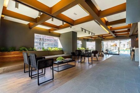 Sala de estar com móveis modernos e iluminação adequada, com vista para a cidade. de kitnet/studio à venda com 1 quarto, 29m² em Pinheiros, São Paulo