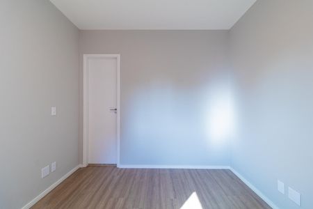 Apartamento à venda com 73m², 4 quartos e 2 vagasQuarto com piso de madeira e porta branca, iluminado por luz natural.