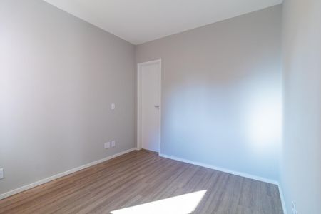 Apartamento à venda com 73m², 4 quartos e 2 vagasQuarto com piso de madeira e porta branca, iluminado por luz natural.