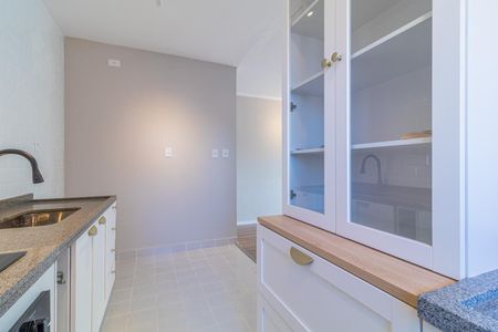 Apartamento à venda com 73m², 4 quartos e 2 vagasCozinha com móveis brancos, bancada de granito e piso de azulejos.